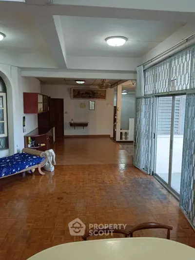 Spacious living room with parquet flooring and sliding glass doors