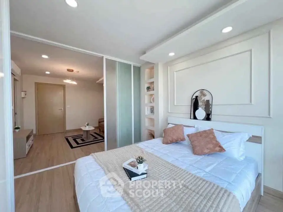 Modern bedroom with stylish decor and sliding glass doors leading to a cozy living area.