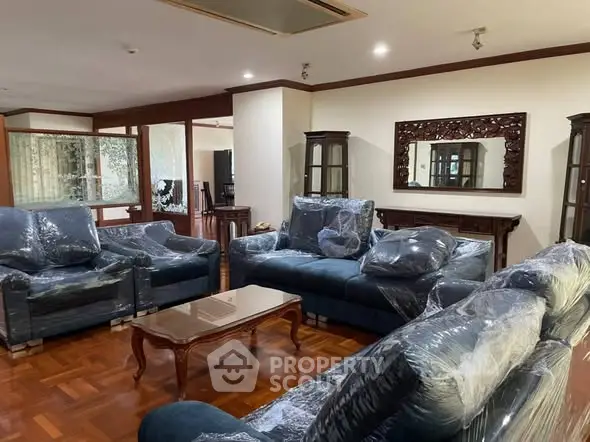 Spacious living room with elegant furniture and wooden flooring, perfect for family gatherings.