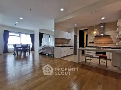 Spacious open-layout living and dining area with modern kitchen in a bright apartment.
