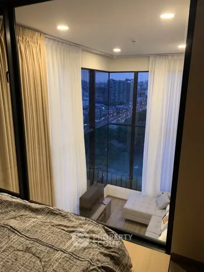 Luxurious corner unit with floor-to-ceiling windows offering stunning city views from the bedroom.