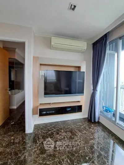 Modern living room with marble floors, wall-mounted TV, and large windows for natural light.