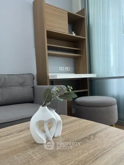 Modern living room with stylish decor and wooden furniture, featuring a cozy gray sofa and elegant vase centerpiece.