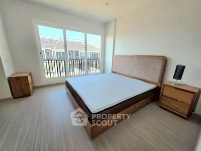 Spacious bedroom with modern wooden furniture and large window view