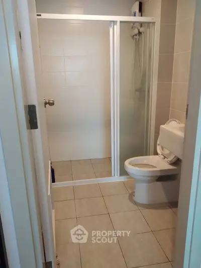 Modern bathroom with glass shower enclosure and tiled flooring