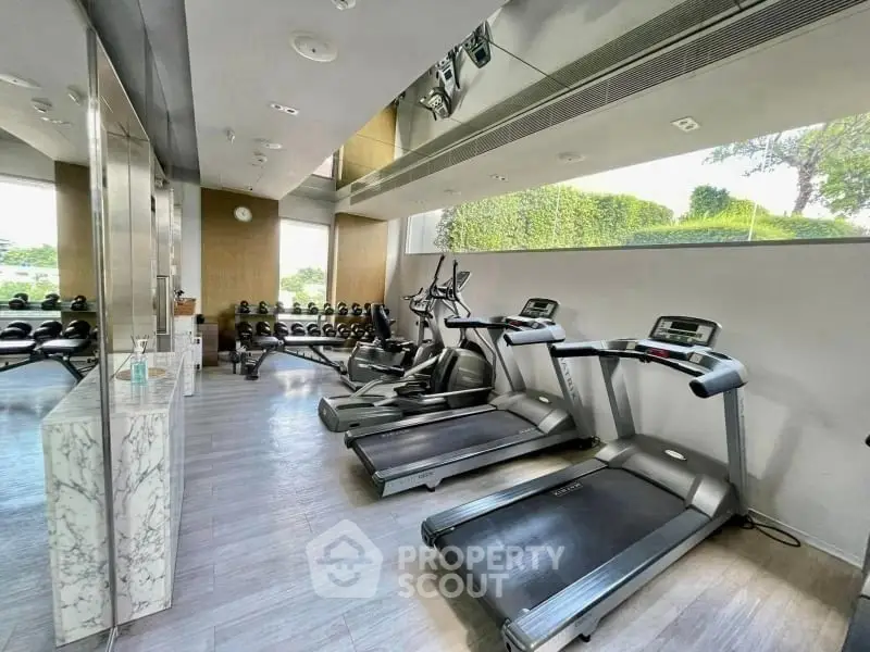 Modern gym with state-of-the-art equipment and scenic views, perfect for fitness enthusiasts.