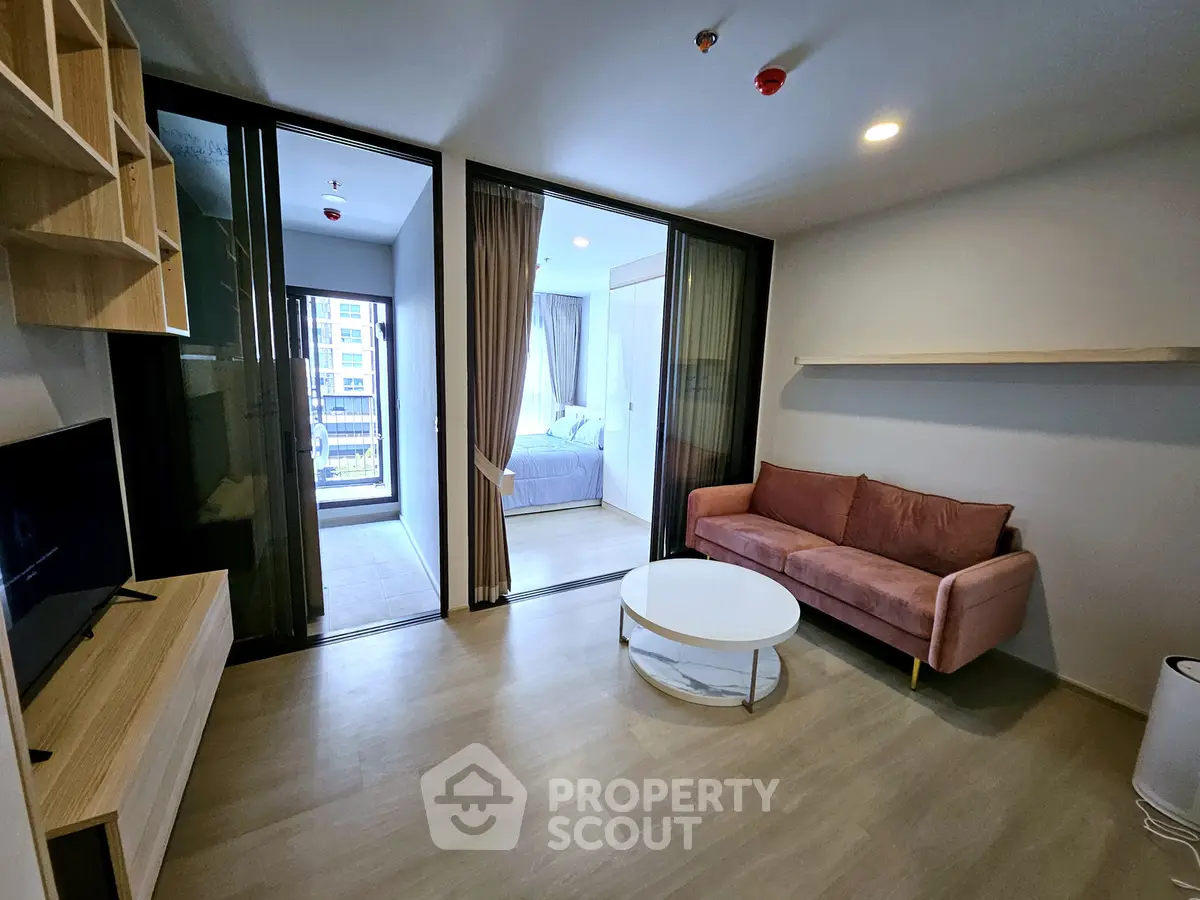 Modern living room with sleek design and cozy bedroom view in open layout apartment.