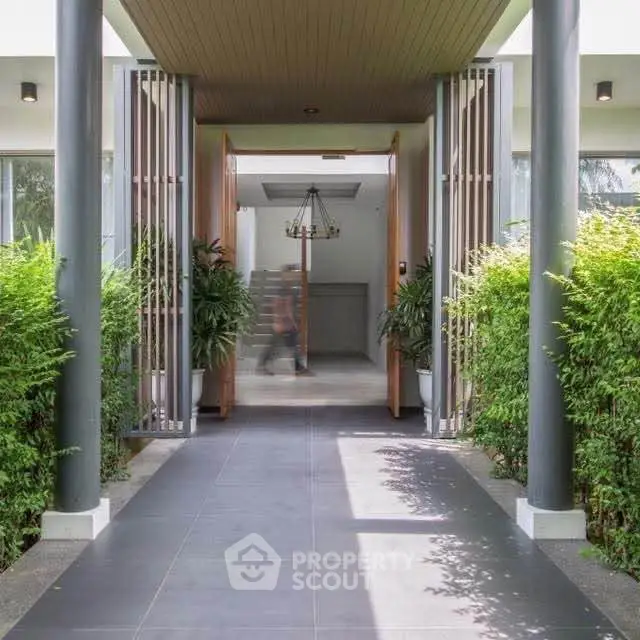 Stunning modern entrance with lush greenery and sleek architectural design.