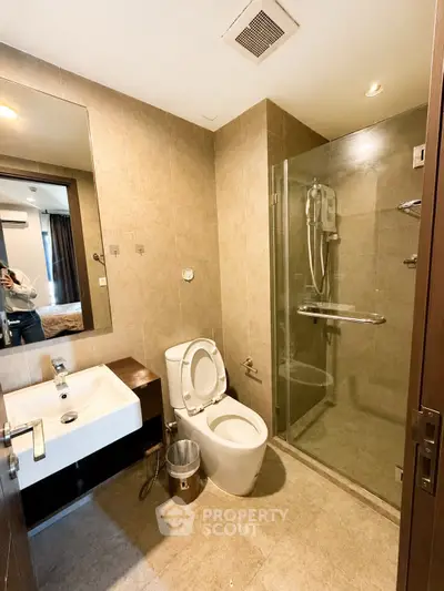 Modern bathroom with glass shower and sleek fixtures in a contemporary apartment.