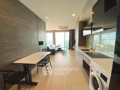 Modern open-plan living room with kitchen and stunning view, featuring sleek furniture and natural light.