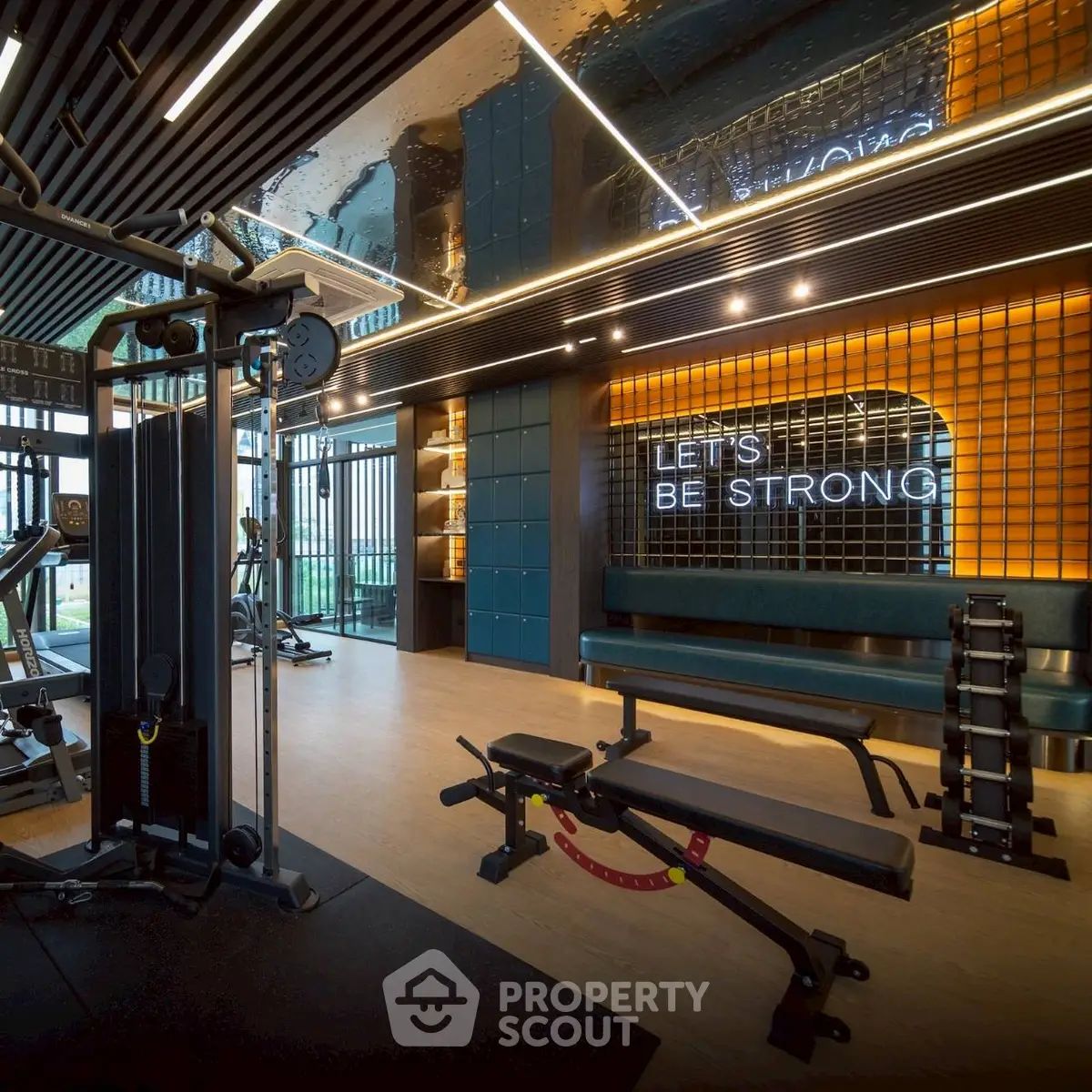 Modern gym with state-of-the-art equipment and motivational decor in luxury residential building.