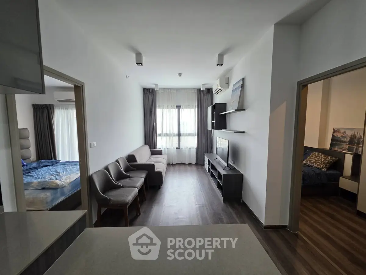 Modern living room with sleek furniture and natural light, adjacent to cozy bedrooms, perfect for urban living.