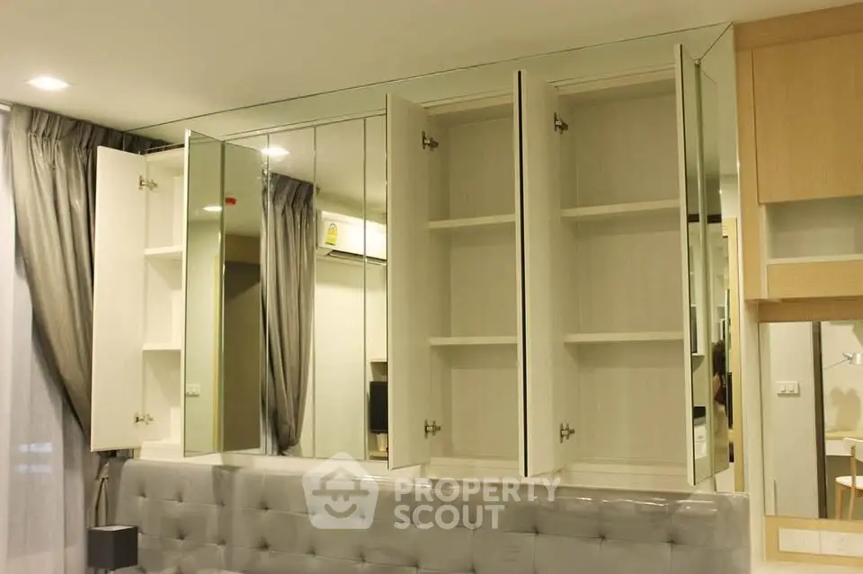 Modern bedroom with mirrored cabinets and elegant gray tufted headboard