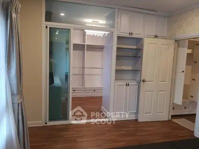 Spacious bedroom with elegant walk-in closet and hardwood floors