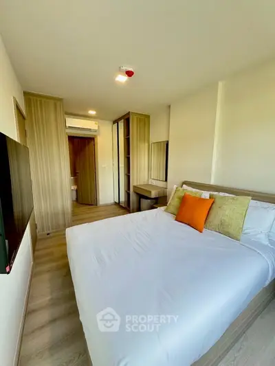 Modern bedroom with cozy bed and stylish decor in a contemporary apartment.