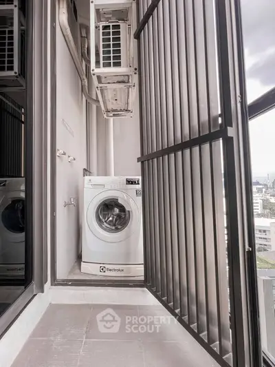 Compact balcony with washing machine and city view, ideal for urban living convenience.