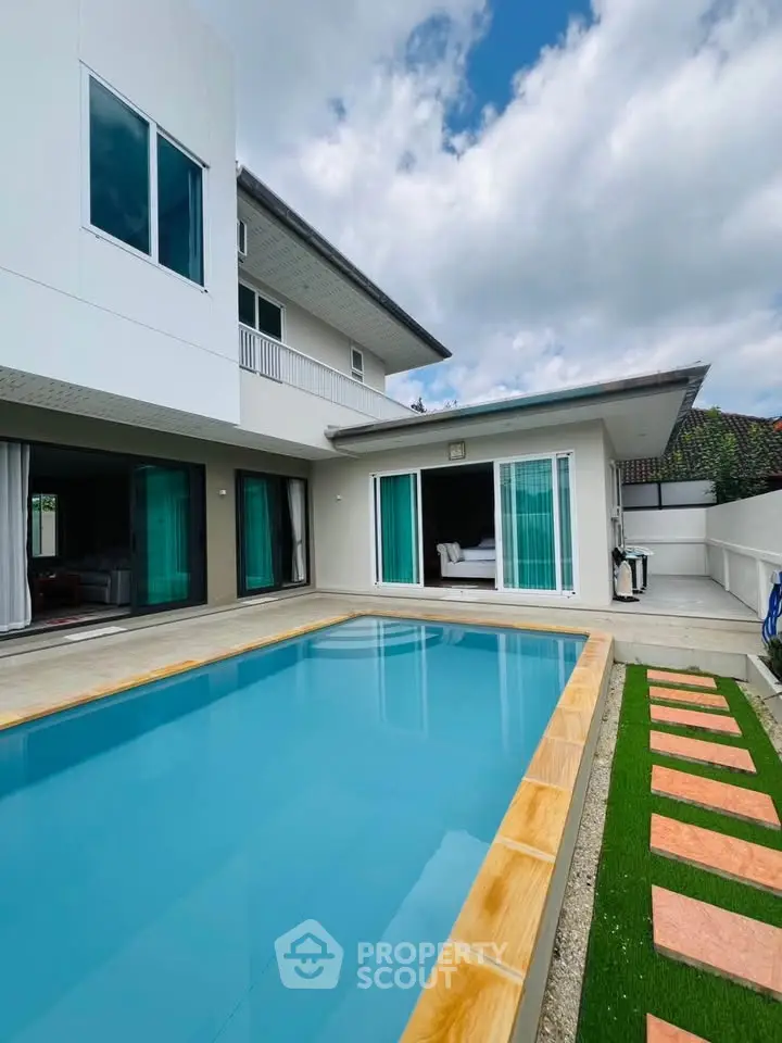 Luxurious modern villa with private pool and spacious outdoor area under a clear blue sky.