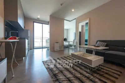 Modern open-layout living room with sleek kitchen and balcony access, featuring stylish furniture and contemporary design.