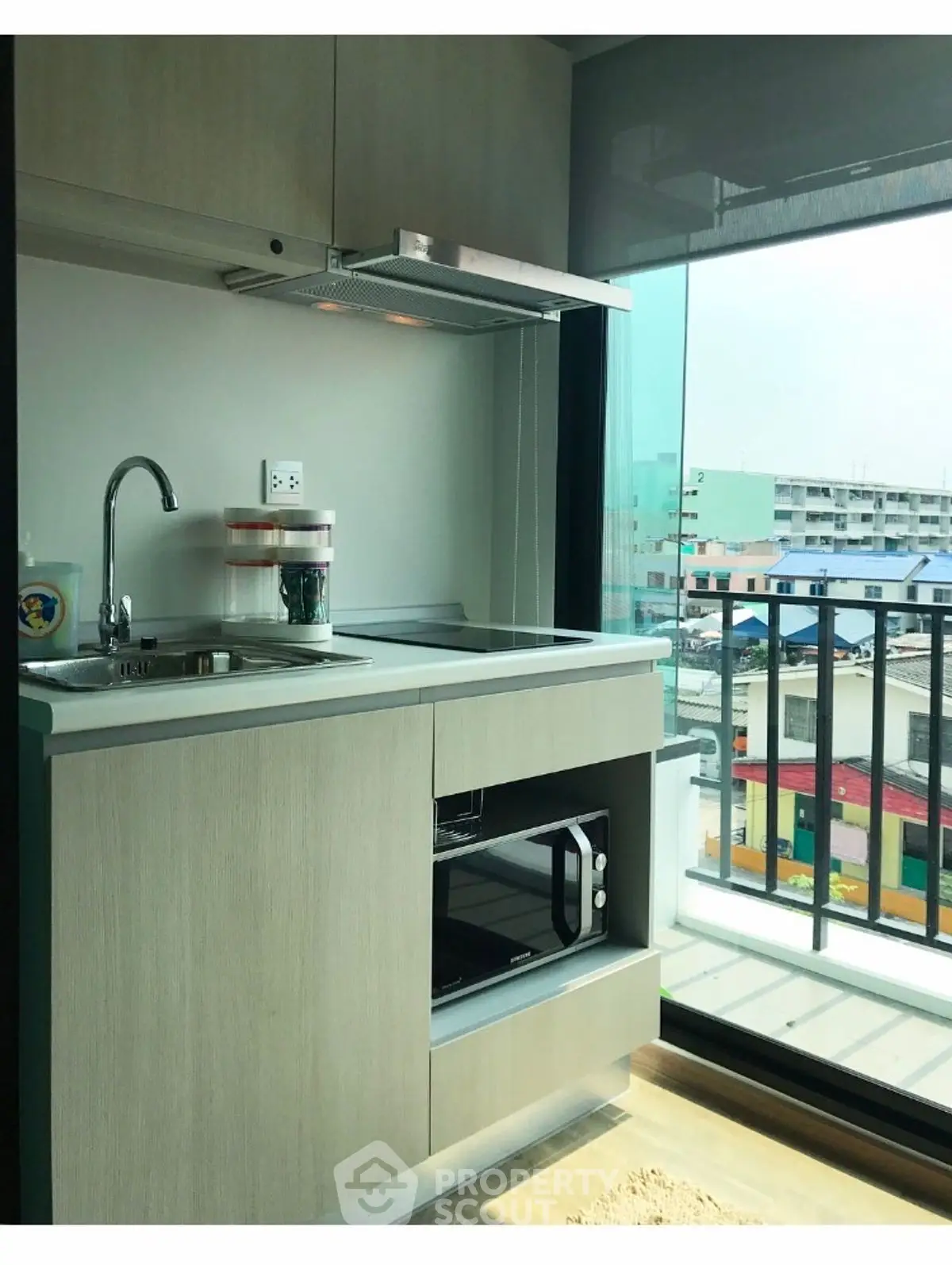 Modern compact kitchen with balcony view in urban apartment