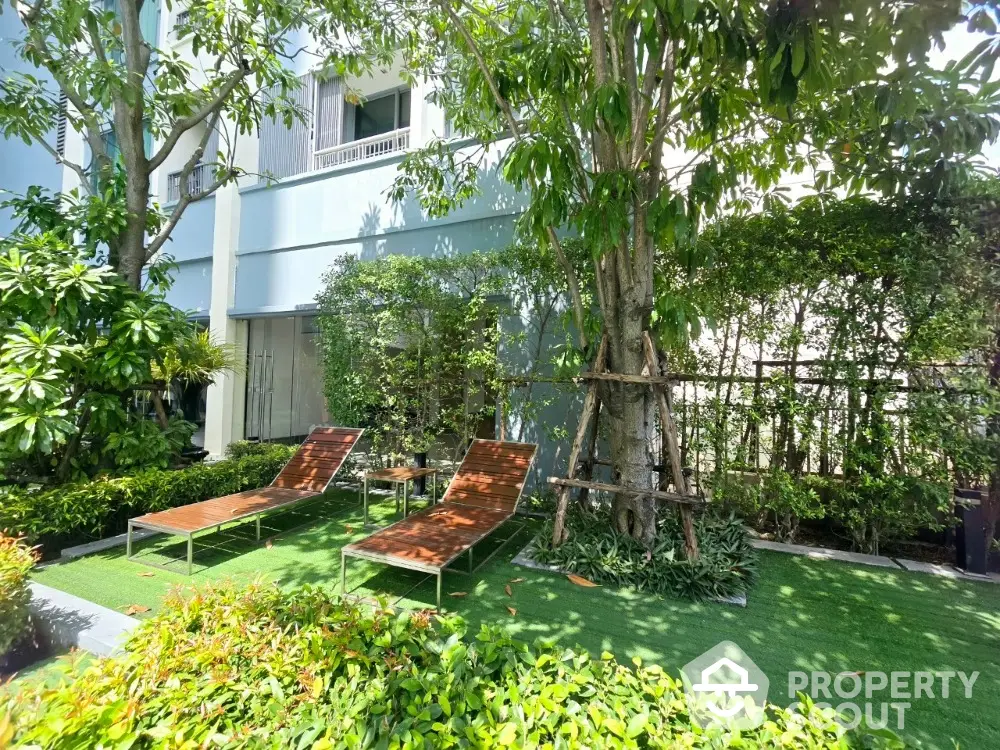 Lush garden area with sun loungers in a modern residential complex