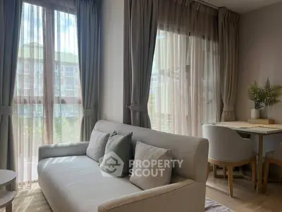 Cozy living room with natural light and modern decor in a stylish apartment.