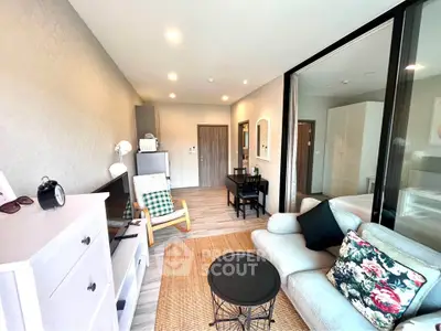 Charming living room with modern decor and cozy seating in a bright apartment.