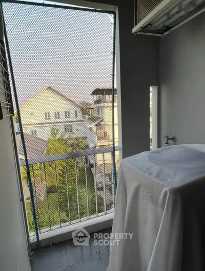 Charming balcony with protective netting and scenic neighborhood view, perfect for relaxation and outdoor enjoyment.