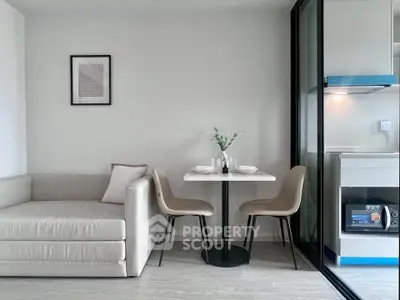 Modern living room with cozy seating and dining area adjacent to sleek kitchen.