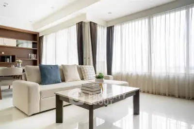 Spacious and bright living room with modern decor and large windows.