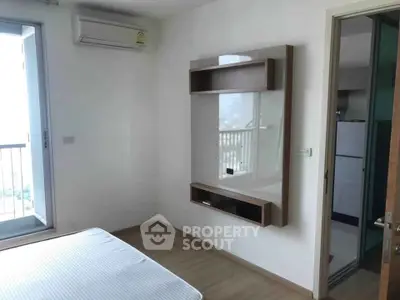 Modern bedroom with balcony access and air conditioning in a stylish apartment.