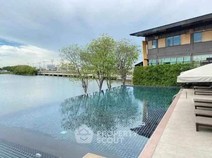 Luxurious infinity pool with serene water views and modern building backdrop.
