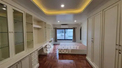Spacious bedroom with elegant built-in storage and large window view