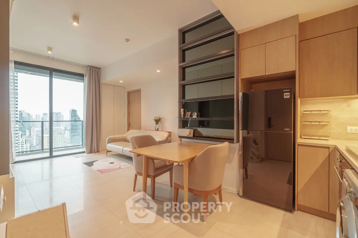 Modern open-plan living room with city view and stylish kitchen in high-rise apartment.