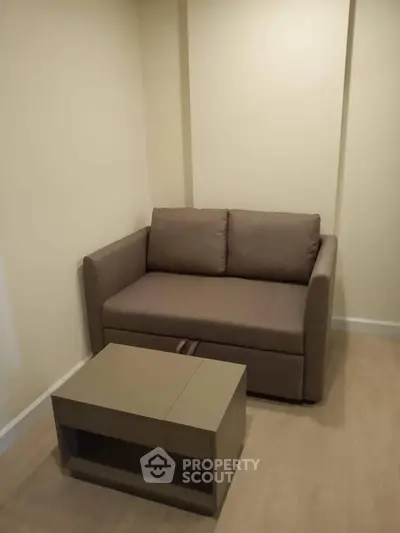 Cozy living room with modern sofa and stylish coffee table in a compact space.