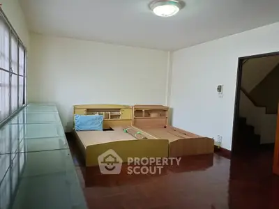Spacious bedroom with wooden flooring and ample natural light