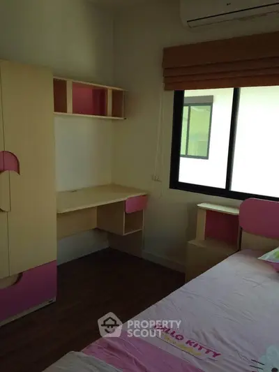 Charming bedroom with Hello Kitty theme, featuring a cozy bed, desk, and ample natural light from the window.
