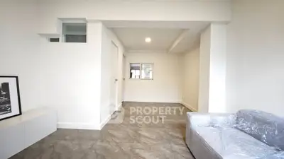 Spacious modern living room with minimalist design and tiled flooring.