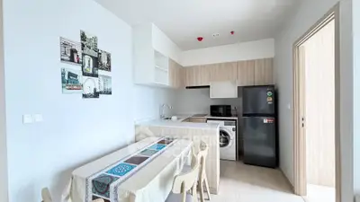 Modern kitchen with dining area, featuring sleek appliances and stylish decor.