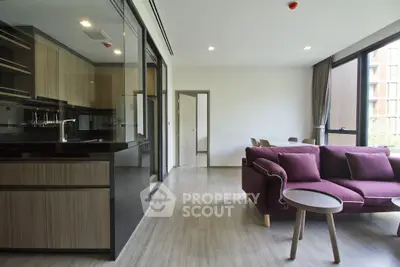 Modern open-layout living room with sleek kitchen and stylish furniture in a contemporary apartment.