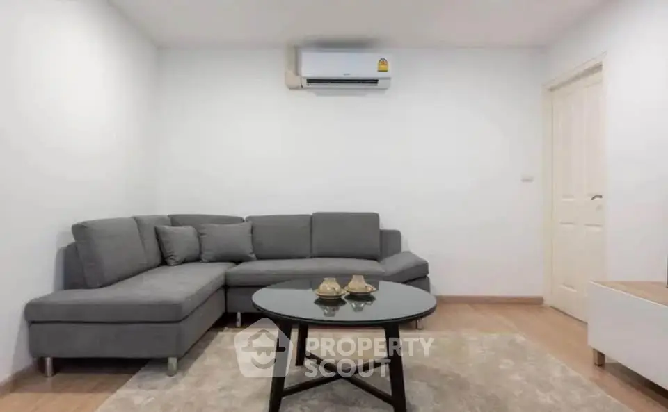 Modern living room with gray sectional sofa and air conditioning