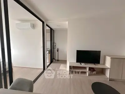 Modern living room with sleek design and open layout, featuring a TV and air conditioning.