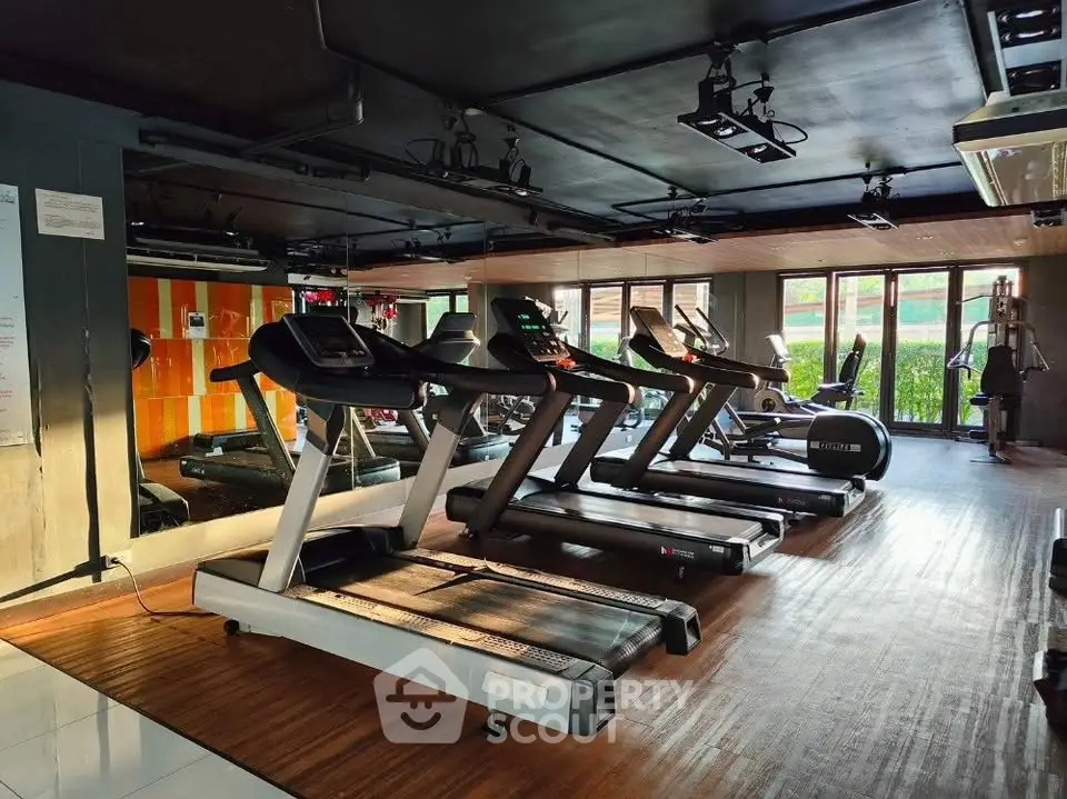 Modern gym with state-of-the-art treadmills and large windows offering natural light.