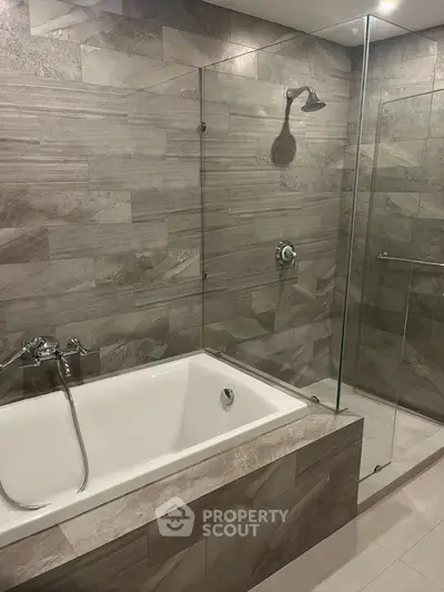 Luxurious modern bathroom with elegant tile design and spacious bathtub.