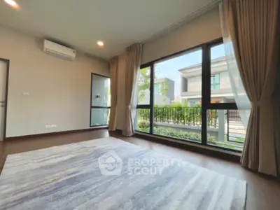 Spacious living room with large windows and modern decor in a luxurious home