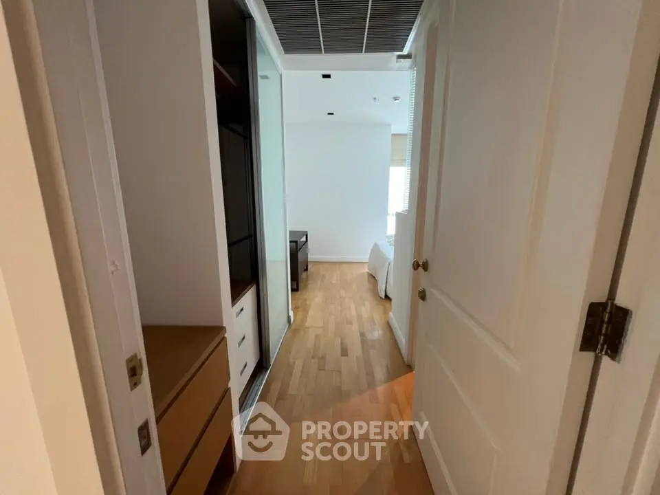 Spacious bedroom with wooden flooring and ample storage space