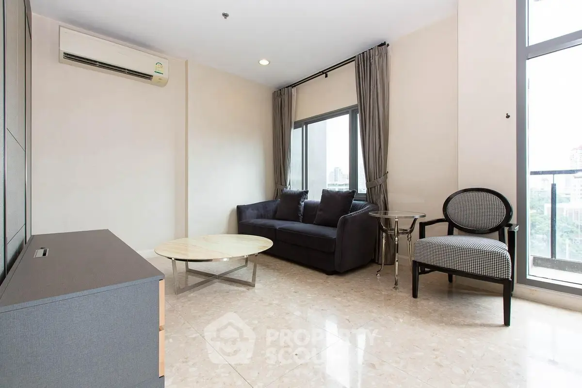 Modern living room with sleek furniture and large windows offering city views.