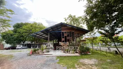 Charming rustic property with open-air design surrounded by lush greenery and ample parking space.