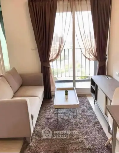 Cozy living room with a sofa, coffee table, and balcony view in a modern apartment.