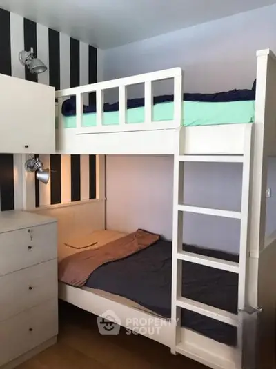 Cozy bedroom with bunk beds and modern lighting, perfect for maximizing space in a small apartment.