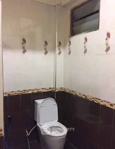 Compact bathroom with tiled walls and modern toilet